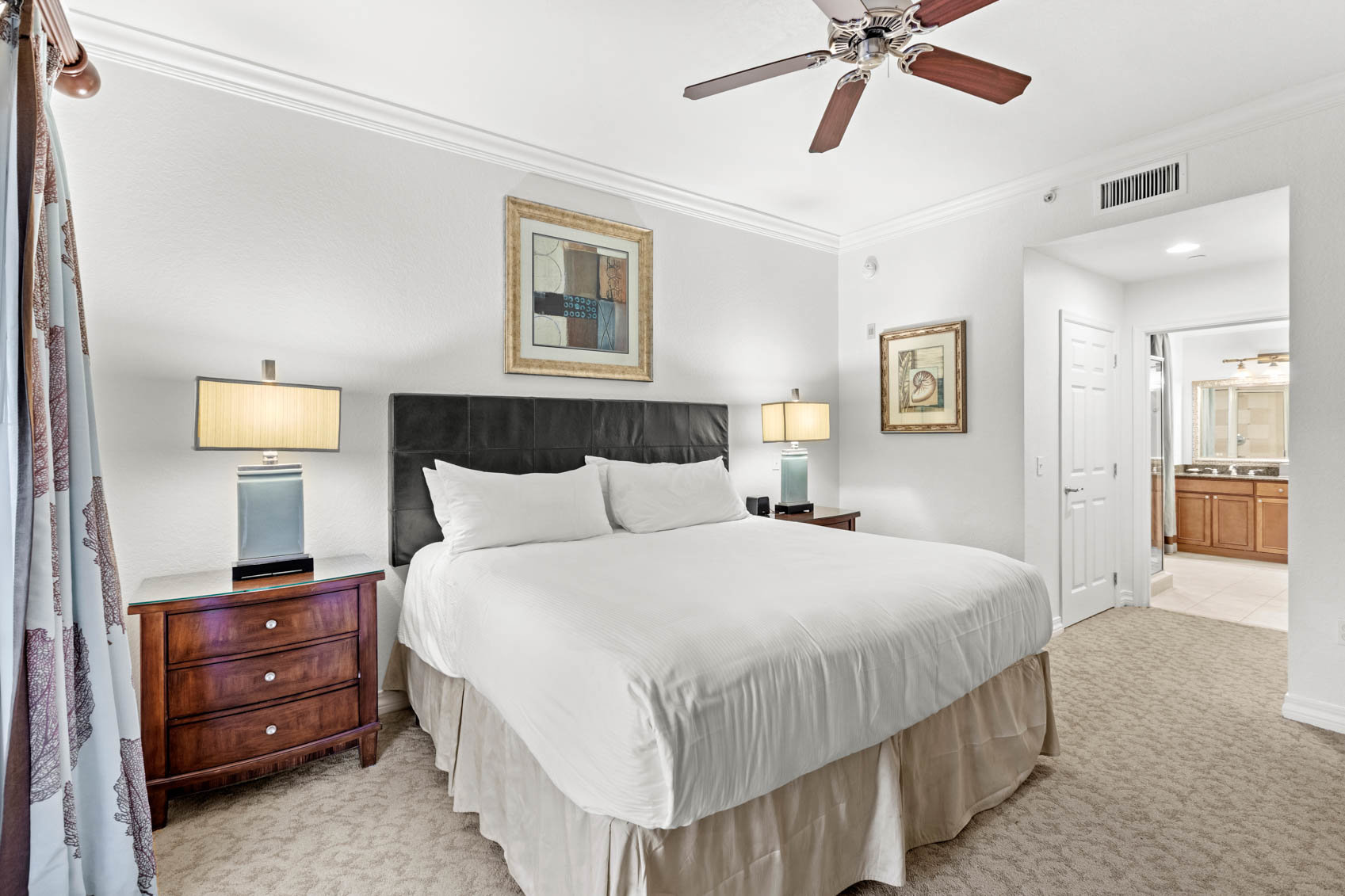 primary bedroom with bed and hallway to bathroom